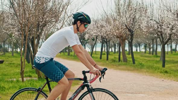 Man Athlete Riding Bicycle in Park