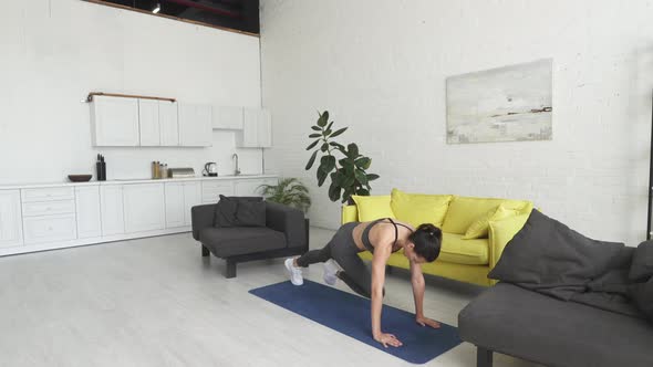 Beautiful Young Woman Doing Exercises on the Floor at Home