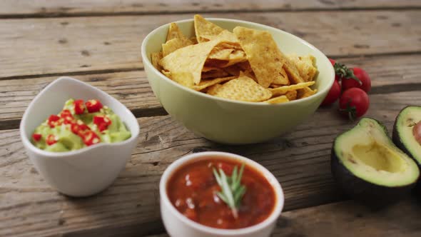 Video of tortilla chips, guacamole and salsa dip on a wooden surface