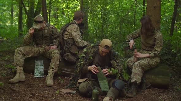 Group of Soldiers Preparing Meal Rations in Forest Resting in Halt