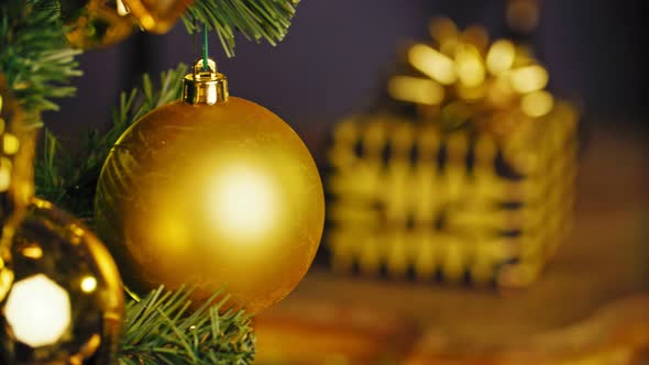 Macro Photo of Golden Ball and Light Garland on Christmas Tree 