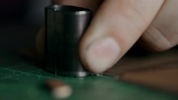 The Process of Manufacturing a Leather Wallet Handmade. The Craftsman Cut Off a Piece of Leather