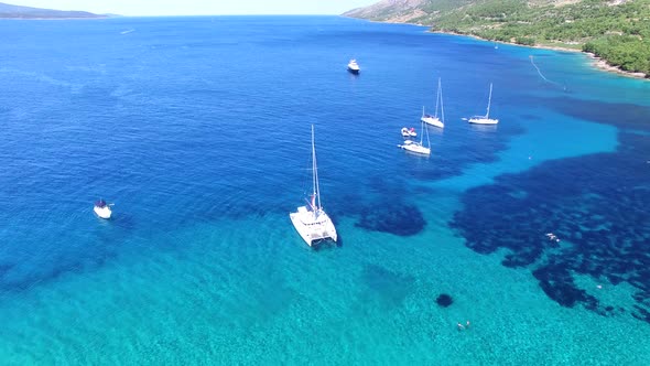 Aerial view of sailing boats and an expensive yacht mooring