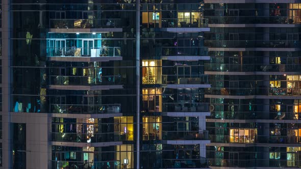 Glowing Windows in Multistory Modern Glass Residential Building Light Up at Night Timelapse