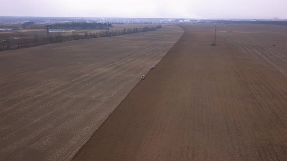 Agricultural Work in the Field, Two Blue Tractors Plow the Land