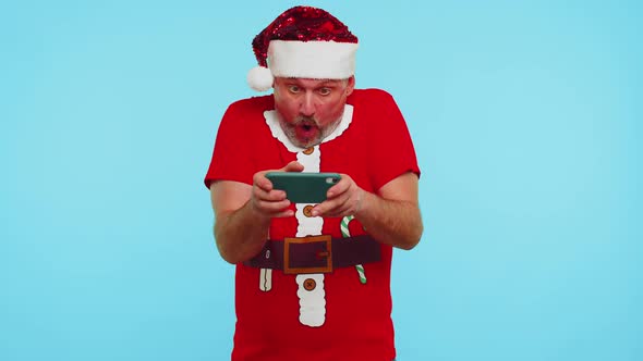 Worried Man in New Year Tshirt and Hat Enthusiastically Playing Racing Video Games on Mobile Phone