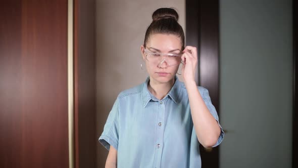 A young girl puts on safety glasses and inserts a drill into the drill