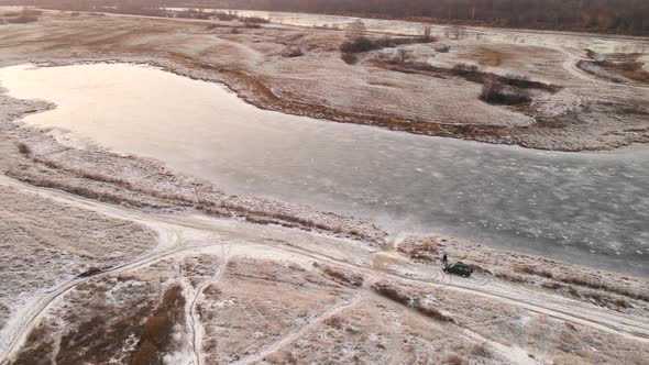 Slope and Lake Under the Snow in the Orange Light of the Sun