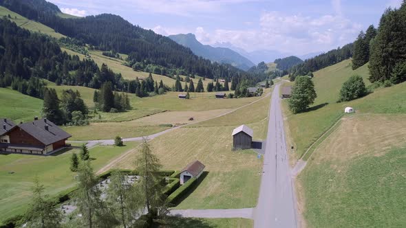 Aerial View of a Valley in Switzerland with Chalets and a Mountainous Landscape