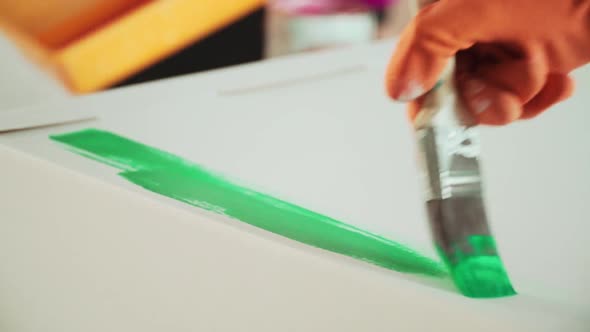 Women Paint White Surfaces with Multicolored Paints