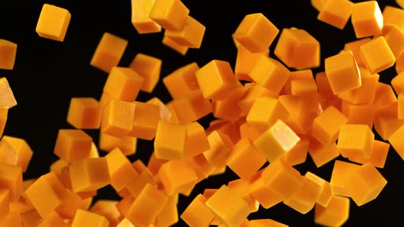 Super Slow Motion Shot of Flying Cheddar Cheese Cubes on Black Background at 1000 Fps