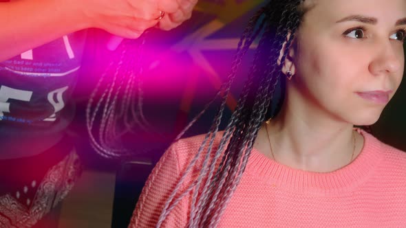 A Female Stylist Attaches Senegalese Braids to a Woman in a Beauty Salon