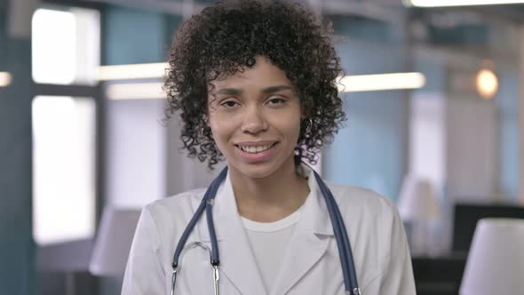 Portrait of Cheerful Young Doctor Waving at Camera and Welcoming