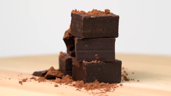 Pile of chocolate pieces with cocoa powder rotating