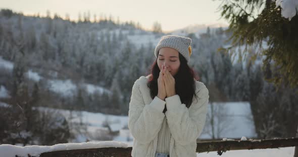 Woman in Winter Clothes Outdoors Against Snowy Mountains and Village