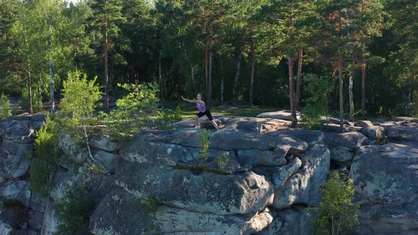 Aerial View of a Girl Doing Fitness and Yoga on the Edge of a Cliff