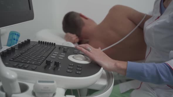 Woman Doctor Makes Heart Check of Patient Man Using Modern Equipment in a Cardiology Clinic