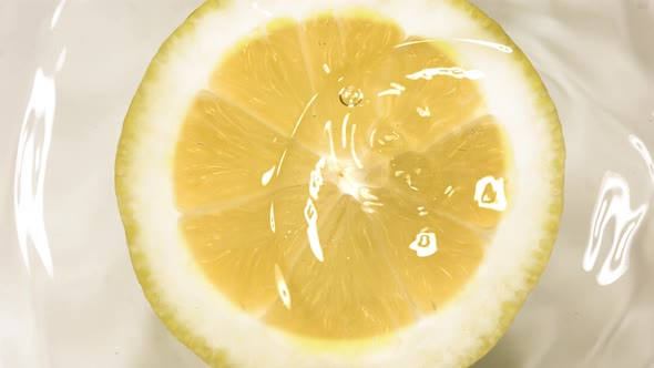 Super Slow Motion of Falling Water Drop on Lemon Slice