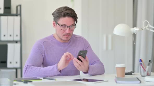 Middle Aged Man Using Smartphone in Office 