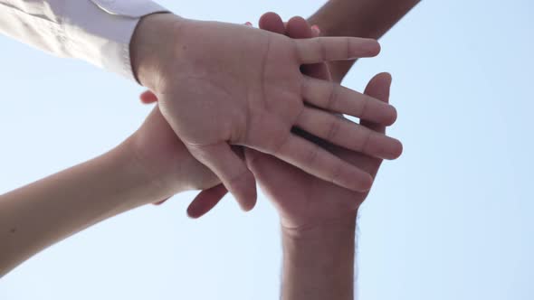 Closeup Handstack of Multiethnic Young People with Clear Blue Sky at Background