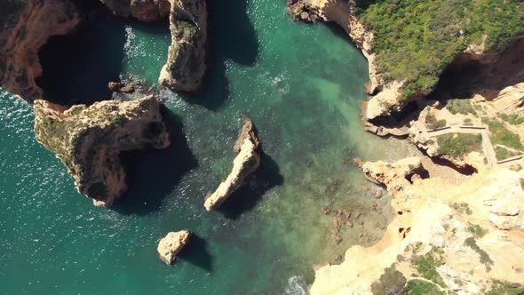 Birds eye view over Rugged jagged Algarve Coastline, In Lagos, Portugal - Aerial Top rotation shot