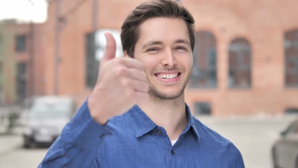 Thumbs Up by Young Man Standing Outdoor