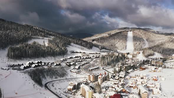 Aerial Footage of Ski Resort Village in Winter Time During Sunny Day with Epic Clouds