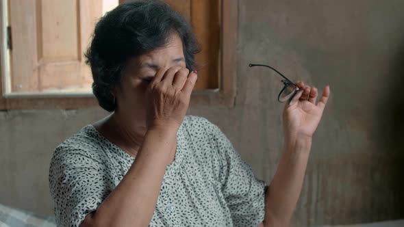 Asian Senior Woman Take Off Glasses And Eyes Pain In Country Home