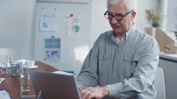 Aged Office Worker Using Laptop