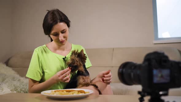 Young Female Influencer Live Streaming Feeding Fast Food To Her Dog