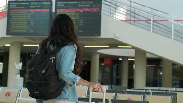 Young Woman Standing in Lobby of the Railway Station with Luggage