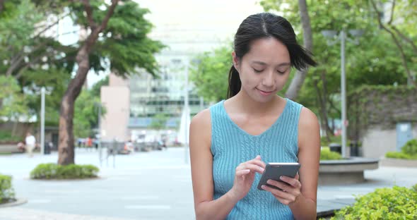 Woman Use of Mobile Phone and Sitting at Outdoor 