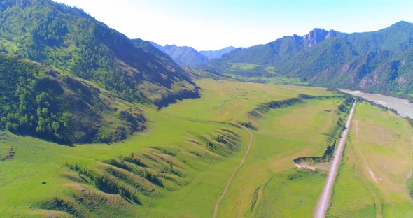 Aerial Rural Mountain Road and Meadow at Sunny Summer Morning