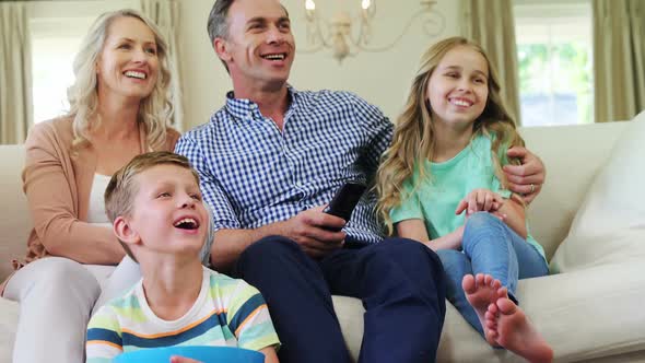 Happy family watching television together in living room