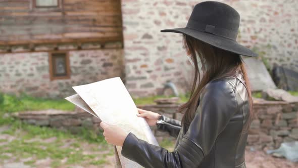 Side View of Female Tourist Exploring Map. New Normal Tourist with Face Mask in Old Town