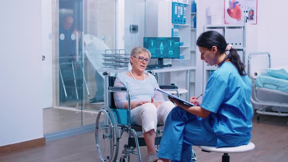 Nurse Talking with Senior Woman in Wheelchair