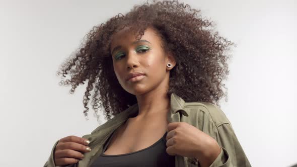 Young Mixed Race Model in Studio on White with Curly Hair, Bright Green Eye Makeup