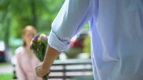 Back View of Teen Boy Presenting Bunch of Flowers to Girlfriend, Surprise