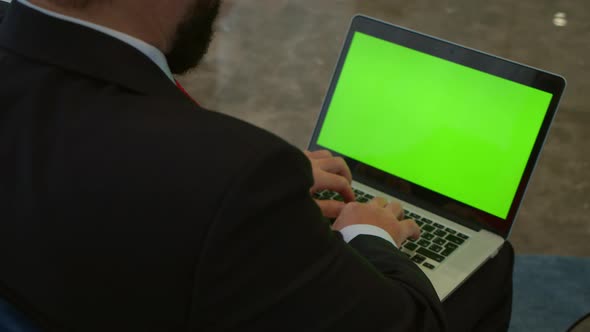 Businessman Working on Laptop Computer in the Office Lobby