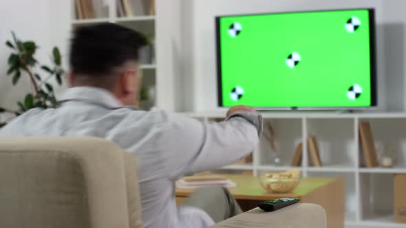 Man Walking into Living Room and Watching TV with Green Screen