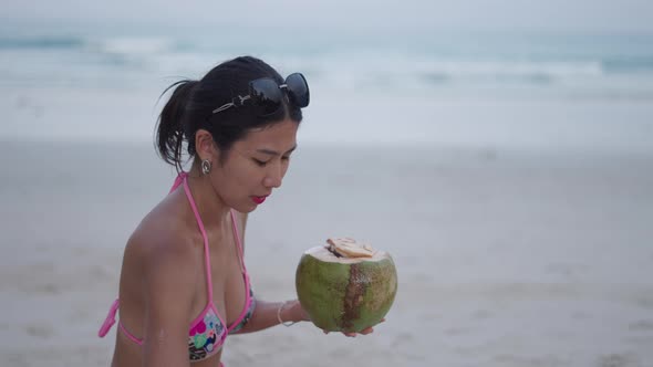 Thai Woman Drinking Coconut Water Having Fun on Summer Vacation at Sunset