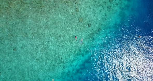 Luxury drone island view of a white sandy paradise beach and turquoise sea background in colorful 4K