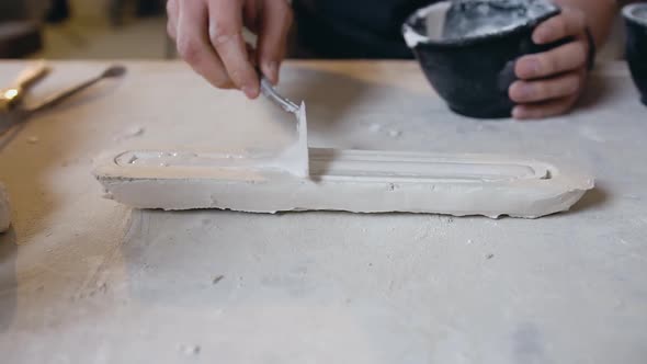 Male Hands which Putting Ready Gypsum Mixture to the Details to the Future Sculpture