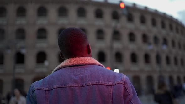 African American guy in stylish clothing walking on street