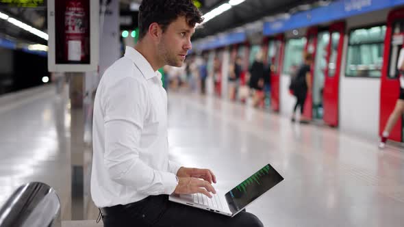 Businessman Using Laptop on Station