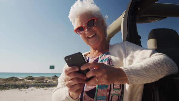 Senior woman with car at the beach