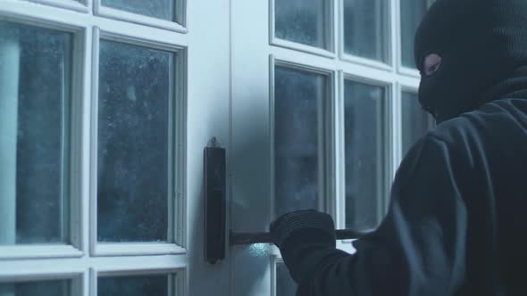 Close Up Of Thief Man Using Crowbar Open The Door Before Entering Someone's House