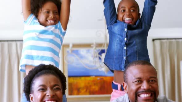 Kids and parents cheering while watching match on television in living room