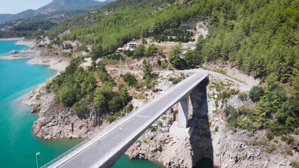 Amazing aerial view of mountain forest and river valley with small bridge.