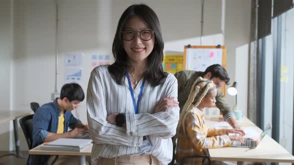 Portrait creative asian businesswoman standing in office workplace with team working behind